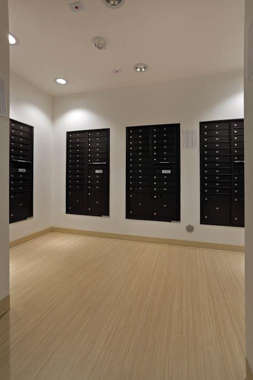 A room with black lockers and wooden flooring.