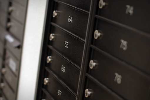 A series of black mailboxes with numbers 64 to 67 are shown.