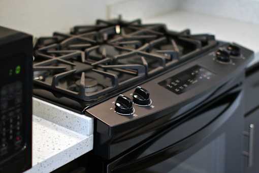 A black gas stove with four burners and a control panel.