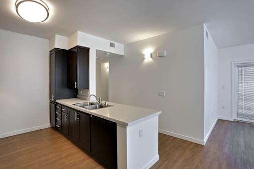 A kitchen with black cabinets and a white countertop.
