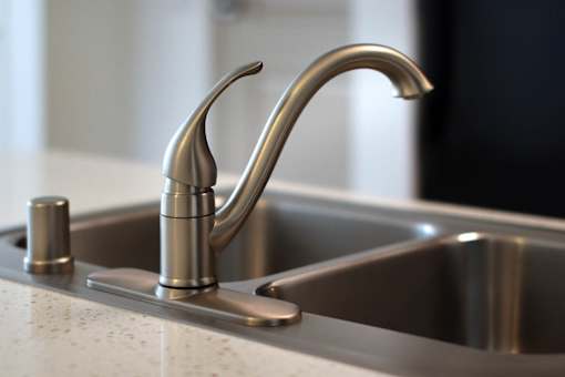 A close up of a chrome kitchen faucet with a pull out sprayer.