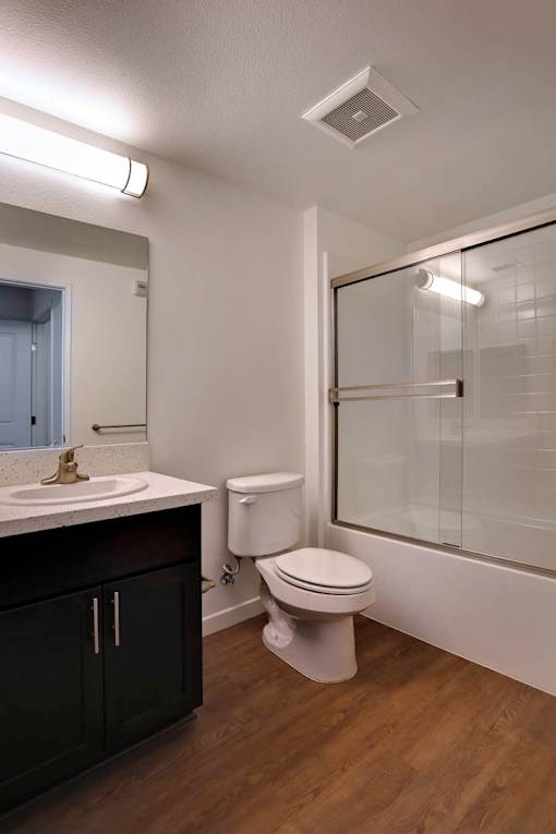 A bathroom with a toilet, sink, and shower.