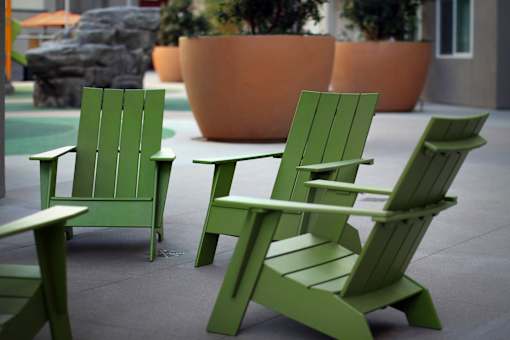 Three green chairs are placed on a patio.