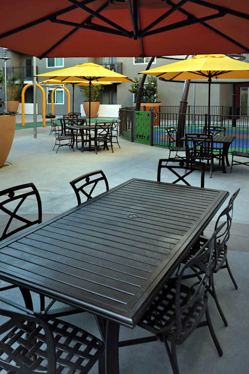 A table and chairs set up under an umbrella.