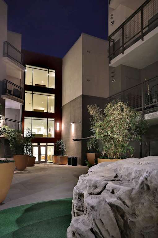 A modern building with a large rock in the foreground.