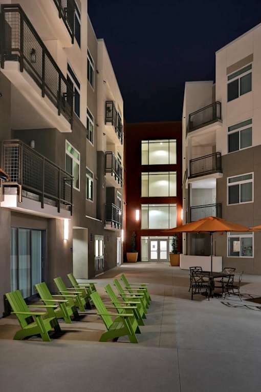 A row of green chairs are lined up on a patio.