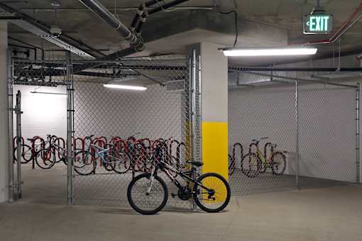 A bicycle is parked in a bike rack in a parking garage.