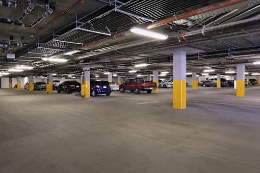 A parking garage with cars parked in yellow columns.