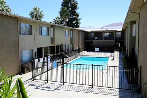 A black iron fence surrounds a small pool.