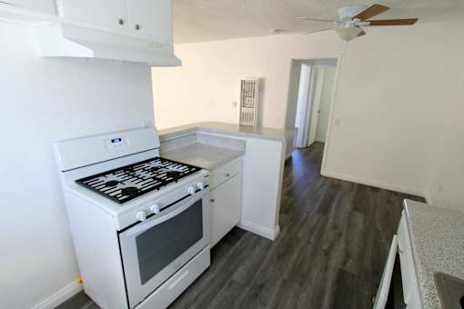 A white stove and oven in a kitchen with wood flooring.