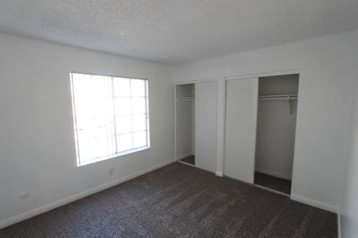A room with a carpeted floor and a window.