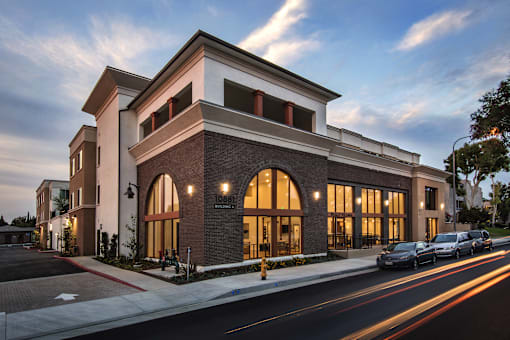 A modern building with a parking lot in front.