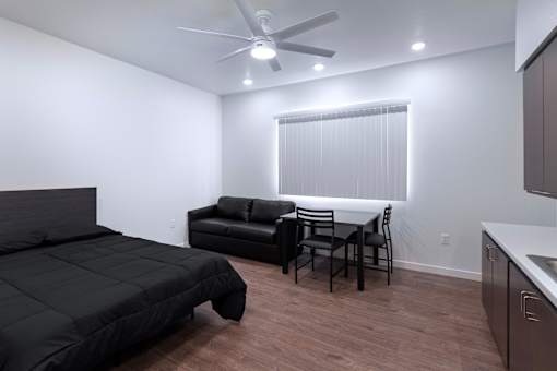 A bedroom with a bed, chair, and table.