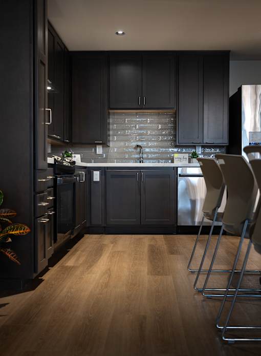 A kitchen with dark wood cabinets and a brick backsplash.