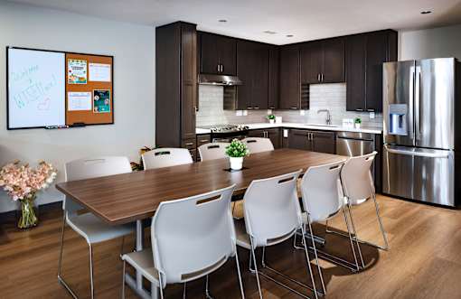 A modern kitchen with a dining table and chairs.