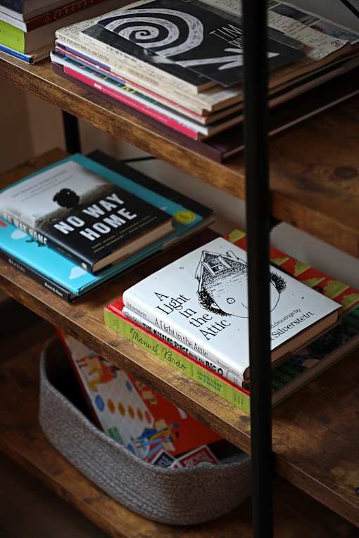 A stack of books on a shelf with a book titled "No Way Home" on top.