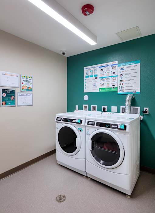 Two front loading washing machines in a laundry room.