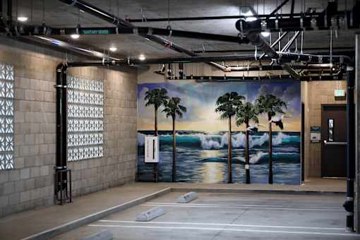 A wall mural depicting a beach scene with palm trees and waves.