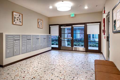 A hallway with a bench, lockers, and a bulletin board.