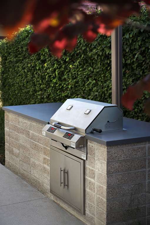 A modern outdoor kitchen with a grill and oven.
