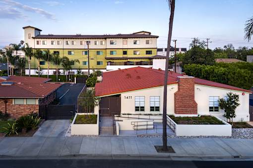A building with a red roof is in the foreground of the image.