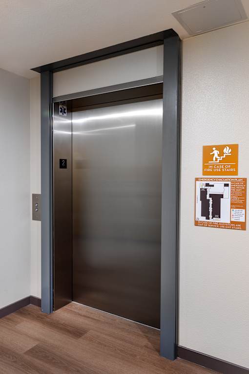 A stainless steel elevator with a sign on the wall.