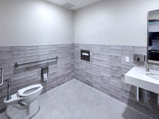 A bathroom with a toilet, sink, and tiled walls.