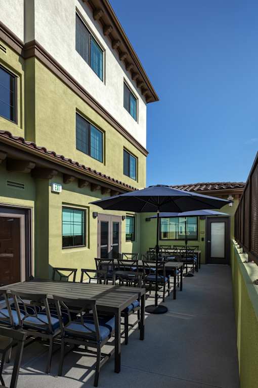 A patio with a table and chairs and an umbrella.