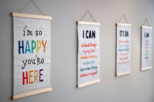 Four posters with positive affirmations are displayed on a wall.