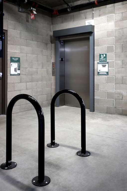 Two black bollards in front of a grey door.