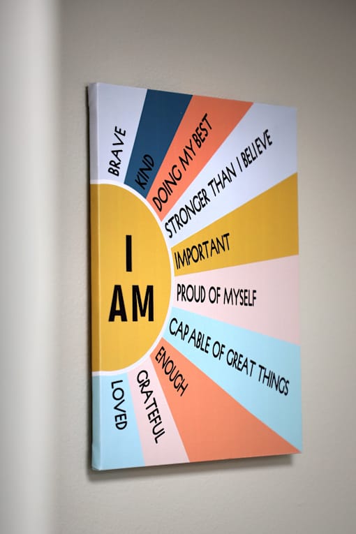 A book with the title "I AM" and various positive attributes written on its cover.