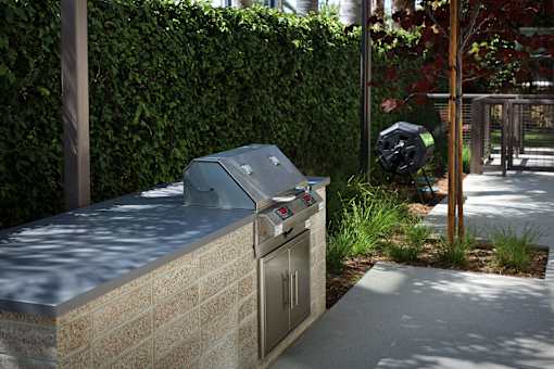 A grey trash can with a black trash bag in it.