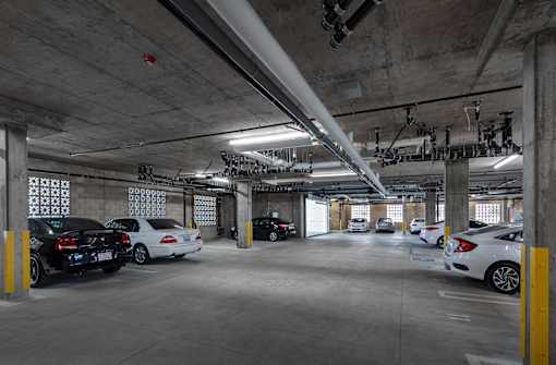 A parking garage with multiple cars parked.