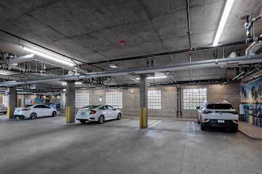 A parking garage with multiple cars parked.