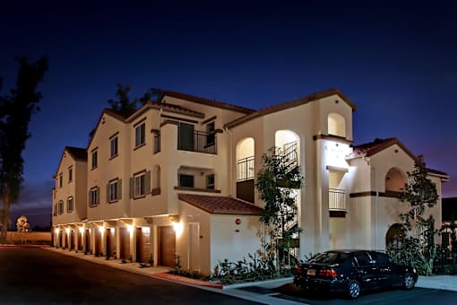 A large house with a car parked in front.