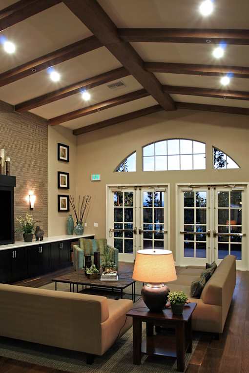 A well-lit living room with a couch, a table, and a fireplace.