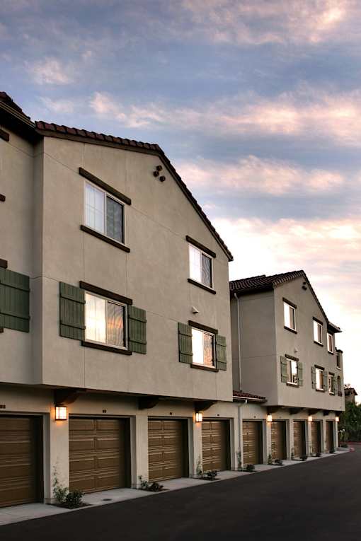 A row of modern townhouses with garages on the ground floor.