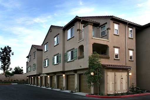 A large apartment building with a parking lot in front.