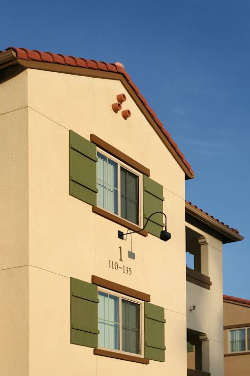 A building with a red tile roof and a sign that reads "110-135" is shown.