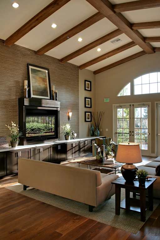 A living room with a couch, a coffee table, and a fireplace.