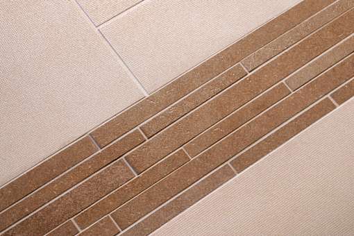 A brown brick is laid on a white tile floor.