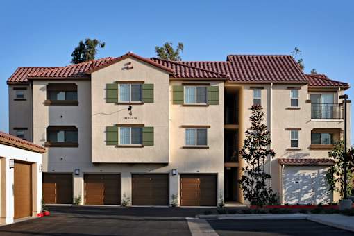 A large two story house with a red tile roof and a garage.