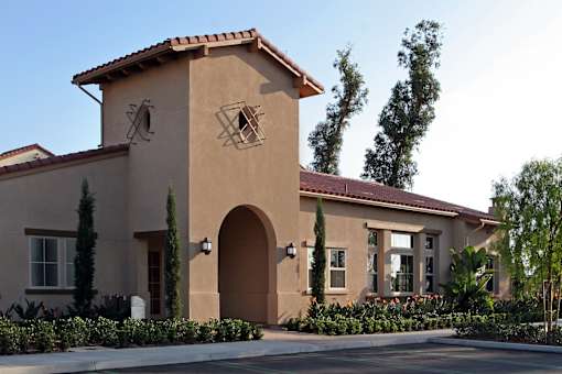 A house with a brown roof and tan walls with a large arched doorway.
