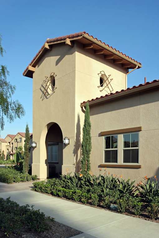 A small building with a brown roof and a clock on it.