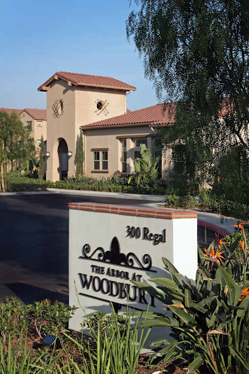 A sign for The Abode at Woodbury sits in front of a house.