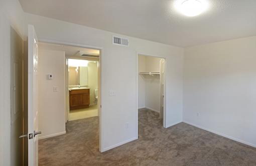 A room with a carpeted floor and a doorway leading to another room.