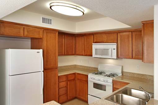 A kitchen with wooden cabinets and white appliances.