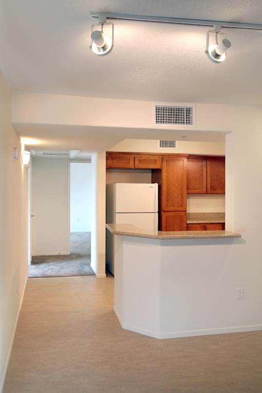 A kitchen with white walls and a white refrigerator.