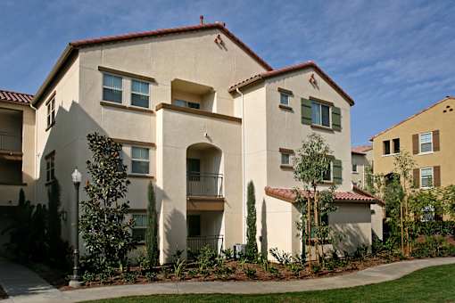 A building with a red tile roof and white walls with balconies.