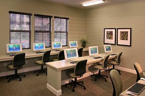 A room with a row of computers on desks.